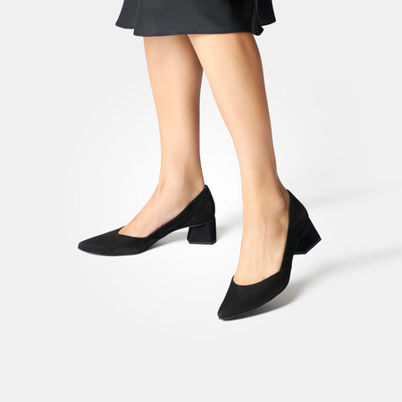 Lady wearing Black Paul Green Witt Pump shoes against a light gray background.